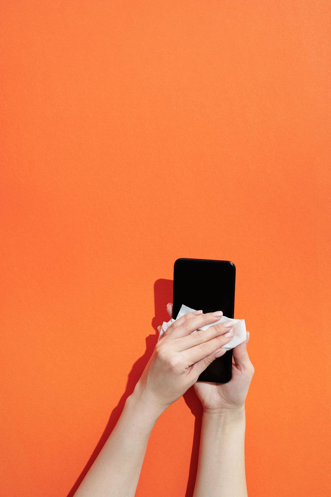 Hands cleaning a personal device
